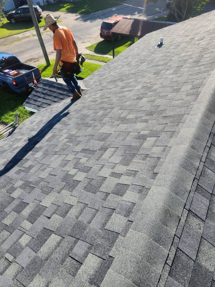 Roofer on a newly finished shingle roof