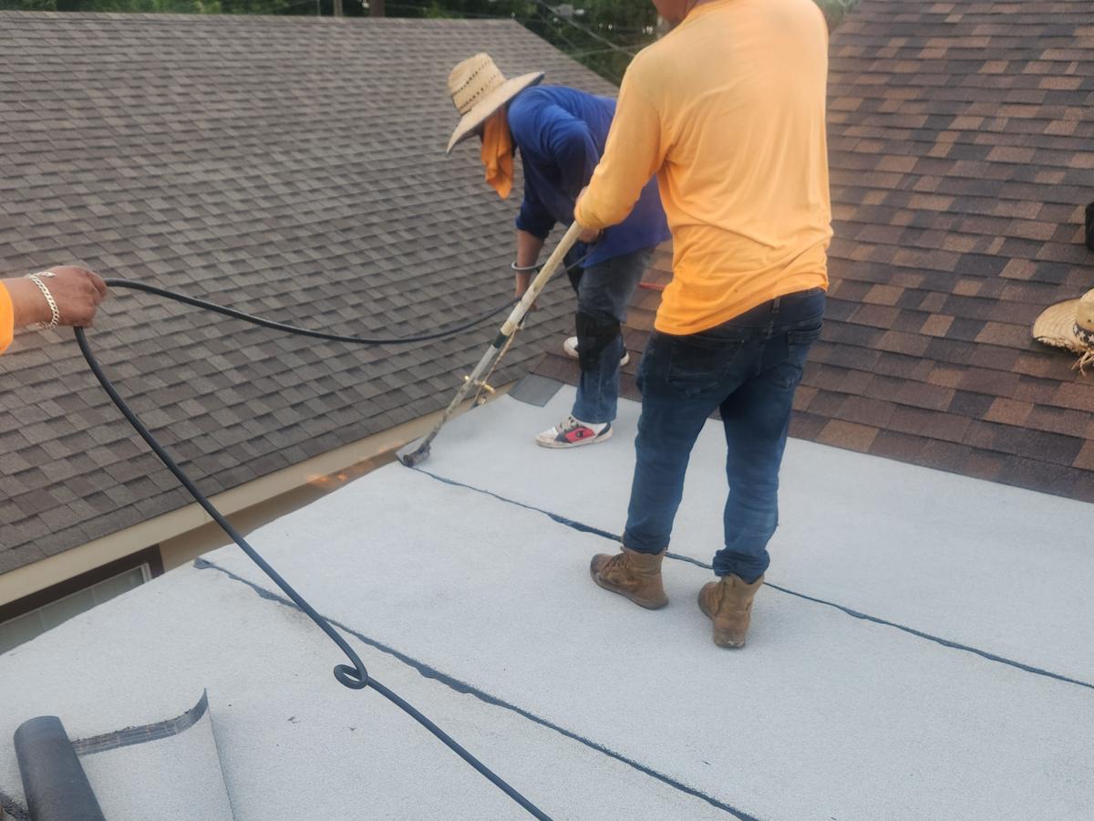 Crew torching down modified bitumen on a flat roof