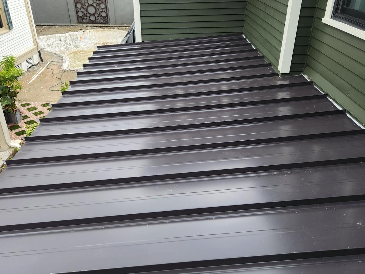 Dark bronze standing seam porch roof on a New Orleans home