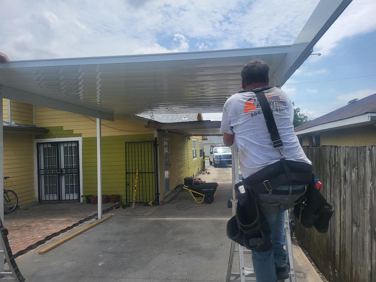 Installing an aluminum carport cover along a driveway