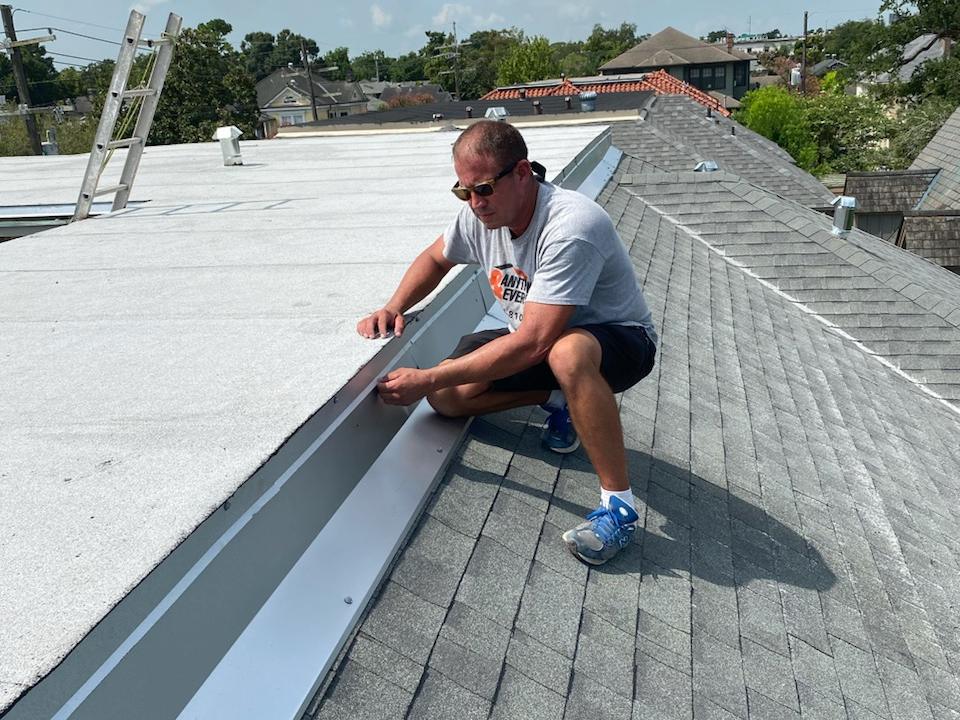 Fitting metal flashing where a flat roof meets shingles