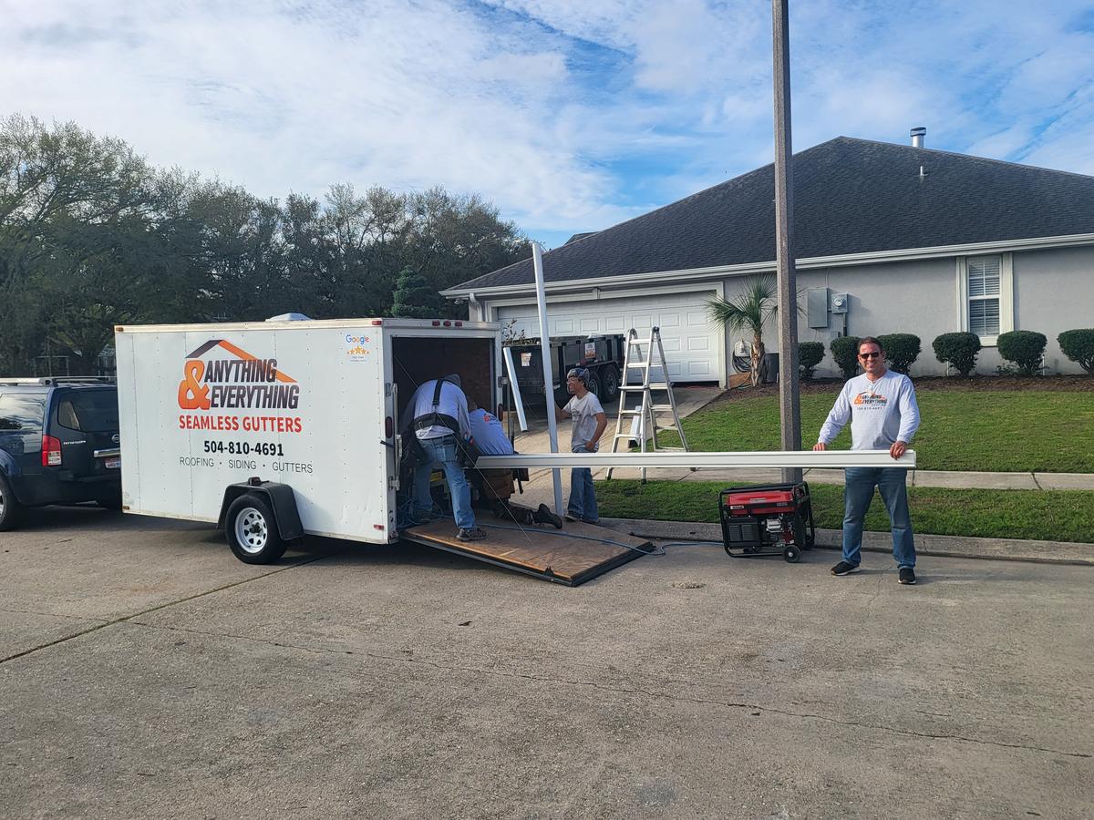 Seamless gutter trailer and crew forming gutters on site